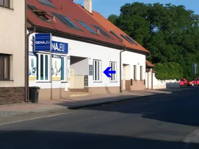 a white building with a red roof and a street at Apartman Amanda in Poděbrady