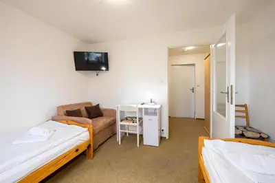 a small room with two beds and a couch at Penzion Vědomice in Vědomice