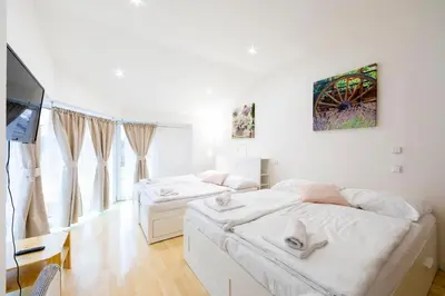 a bedroom with two beds and a flat screen tv at Penzion Vědomice in Vědomice