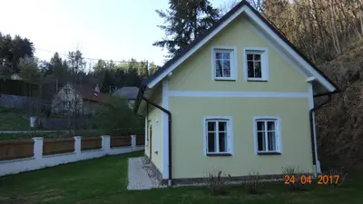 a white house with a fence in a yard at Chaloupka za potůčkem in Županovice
