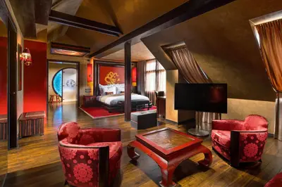 a hotel room with a bed and red chairs at Buddha-Bar Hotel Prague in Prague