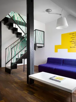 a living room with a blue couch and a staircase at MOODs boutique hotel in Prague