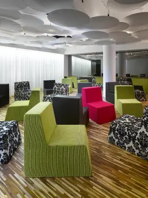 a waiting room with colorful chairs and tables at MOODs boutique hotel in Prague