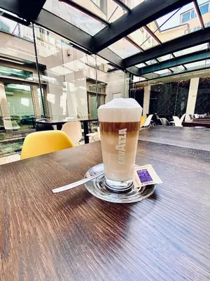 a cup of coffee sitting on top of a table at MOODs boutique hotel in Prague