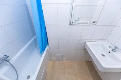 a white bathroom with a sink and a tub and a mirror at Apartments Stepanska 36 in Prague