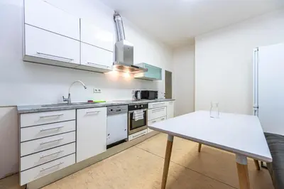 a kitchen with white cabinets and a table at Apartments Stepanska 36 in Prague