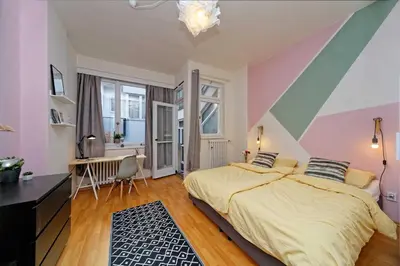 a bedroom with a bed with a striped wall at Apartments Stepanska 36 in Prague