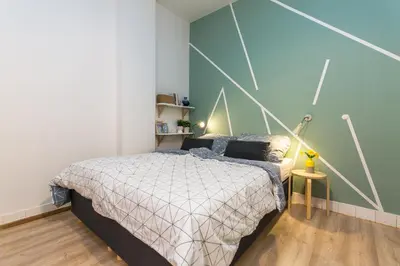 a bedroom with a bed and a blue wall at Apartments Stepanska 36 in Prague