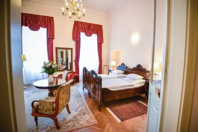 a bedroom with a bed and a table and a chair at Château Liblice in Byšice