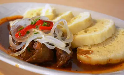 a bowl of food with bread and meat and onions at Hotel Koruna in Karlštejn