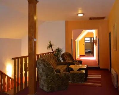 a living room with a chair and a table at Hotel Koruna in Karlštejn