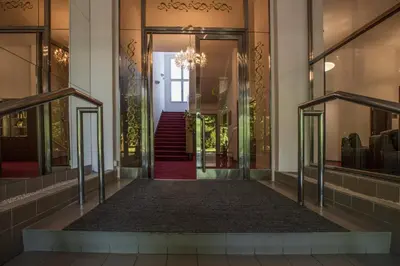 a hallway of a building with glass doors at Hotel Bellevue Tlapak in Poděbrady