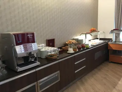 a kitchen counter with a coffee maker and food on it at Hotel Bellevue Tlapak in Poděbrady
