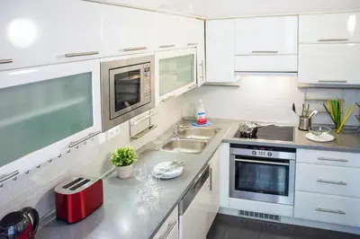 a white kitchen with a sink and a microwave at Apartment Jindrisska 25 in Prague