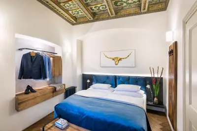 a bedroom with a blue bed and a ceiling at MOOo by the Castle in Prague