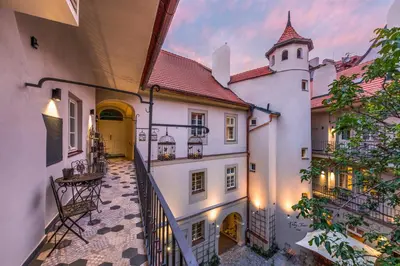 an empty courtyard of a building with a tower at MOOo by the Castle in Prague