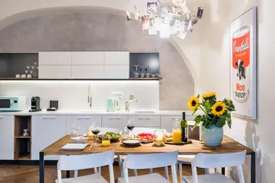 a kitchen with a wooden table with chairs and a vase of flowers at MOOo by the Castle in Prague