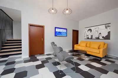 a living room with a yellow couch and chairs at Rozmaryn Rooms & Apartments in Rakovník