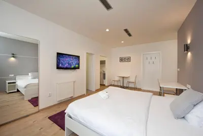 a bedroom with a bed and a tv on the wall at Rozmaryn Rooms & Apartments in Rakovník