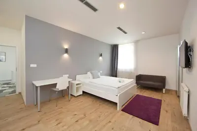 a living room with a white couch and a table at Rozmaryn Rooms & Apartments in Rakovník