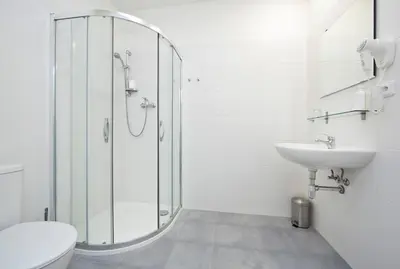 a bathroom with a shower and a toilet and a sink at Rozmaryn Rooms & Apartments in Rakovník