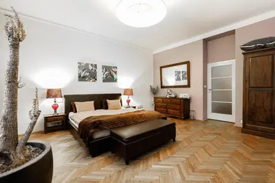 a bedroom with a bed and a table and a tree at LUXURY Apartment Dlouha in Prague