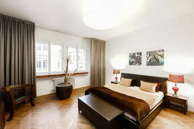 a bedroom with a large bed and a chair at LUXURY Apartment Dlouha in Prague
