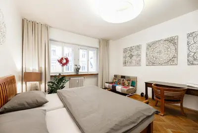 a bedroom with a bed and a table and a chair at LUXURY Apartment Dlouha in Prague