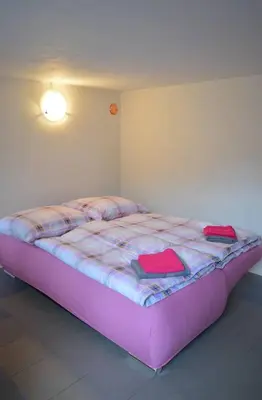 a bed in a room with a purple bed frame at U Lokálky in Zadní Třebaň
