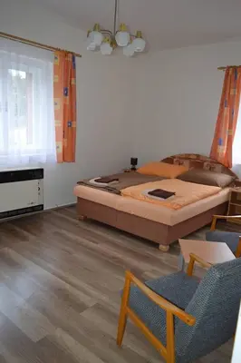 a bedroom with a large bed and a table and chairs at U Lokálky in Zadní Třebaň