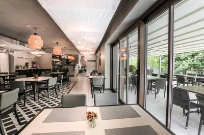 a restaurant with tables and chairs and windows at Hotel Mandát in Hradištko