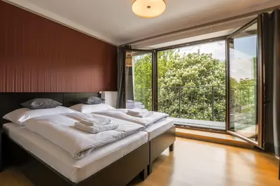 a bedroom with two beds and a large window at Hotel Mandát in Hradištko