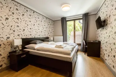 a bedroom with a large bed with a floral wall at Hotel Mandát in Hradištko