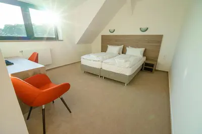 a bedroom with a bed and a desk and a chair at Penzion Koráb in Prague