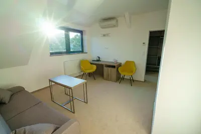 a living room with a couch and two yellow chairs at Penzion Koráb in Prague