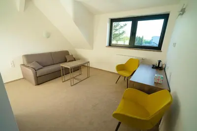 a living room with a couch and a table and chairs at Penzion Koráb in Prague