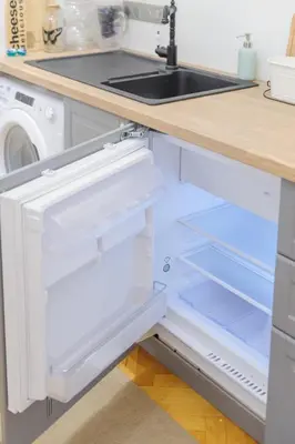 an open refrigerator in a kitchen with a sink at Pinkova Apartments in Prague