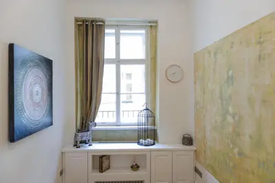 a room with a window and a dresser with a clock at Pinkova Apartments in Prague
