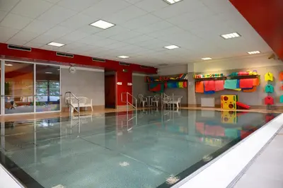 a room with a swimming pool with tables and chairs at Sporthotel Zimní stadion Benešov in Benešov
