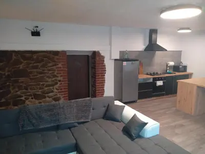 a living room with a couch and a kitchen at Apartman pod Svatou Horou in Příbram