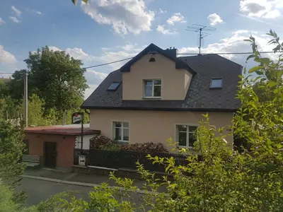 a white house with a black roof at Apartman pod Svatou Horou in Příbram