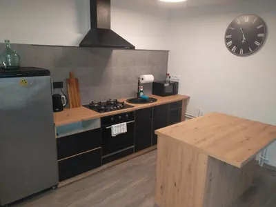 a kitchen with a stove and a counter with a clock at Apartman pod Svatou Horou in Příbram