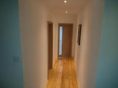 a hallway with white walls and a wooden floor at Apartman pod Svatou Horou in Příbram