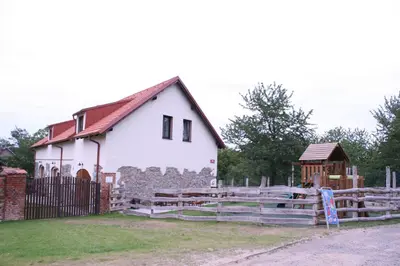 a white barn with a fence and a gate at Statek Malčany in Čím