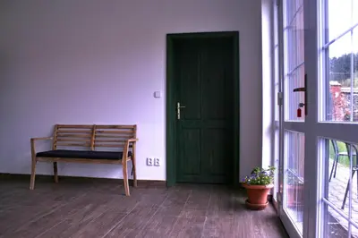 a green door and a chair in a room at Statek Malčany in Čím