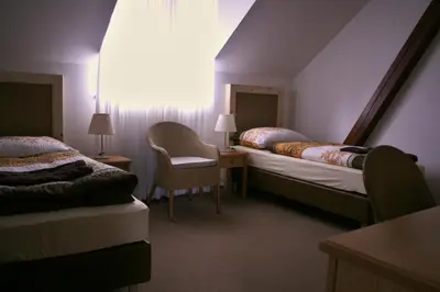 a hotel room with two beds and a chair at Statek Malčany in Čím