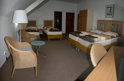 a hotel room with two beds and a table and chairs at Statek Malčany in Čím