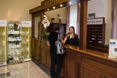 two women standing at a counter in a store at Hejtmanský dvůr in Slaný