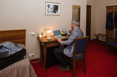 a man sitting at a desk with a laptop computer at Hejtmanský dvůr in Slaný