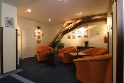 a waiting room with orange chairs and tables at Hejtmanský dvůr in Slaný